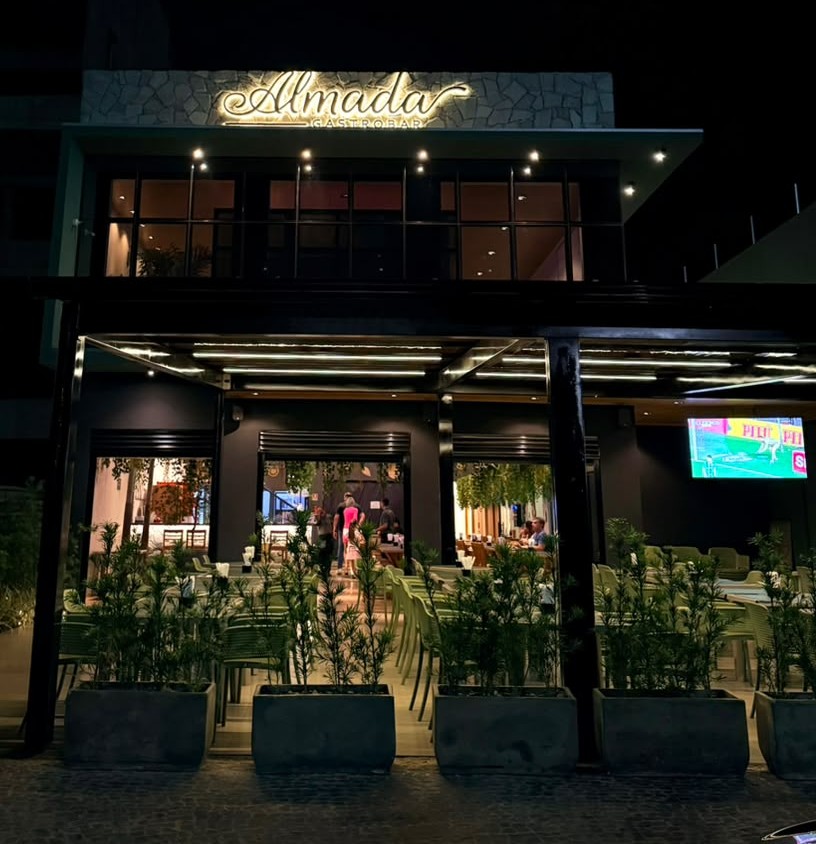 Fachada iluminada do Almada Gastrobar à noite em Rio Verde